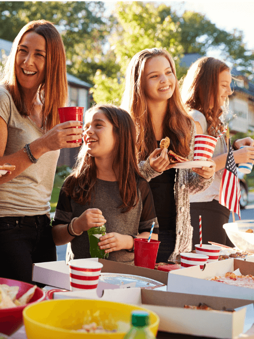 alt text = "a group of girls enjoying a neighborhood block party"