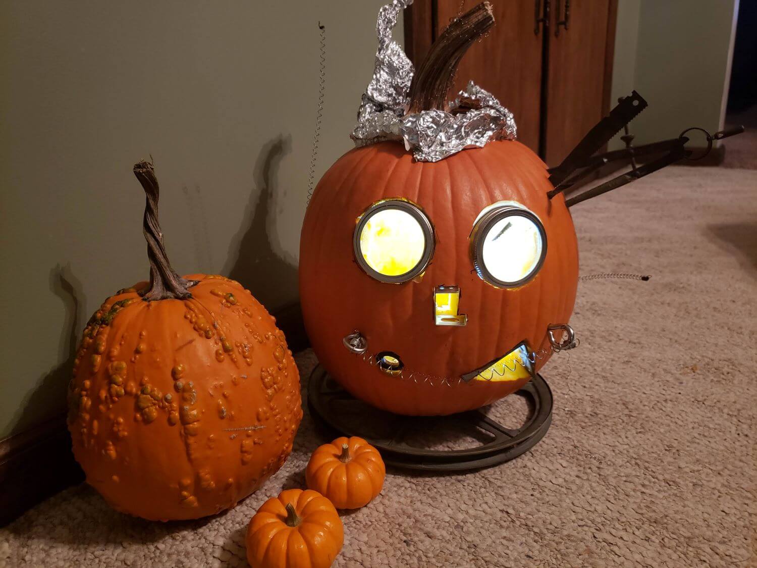 alt text =gourds and a pumpkin carved like a robot"