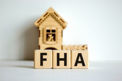alt="FHA financing is depicted by wooden blocks that spell out FHA"