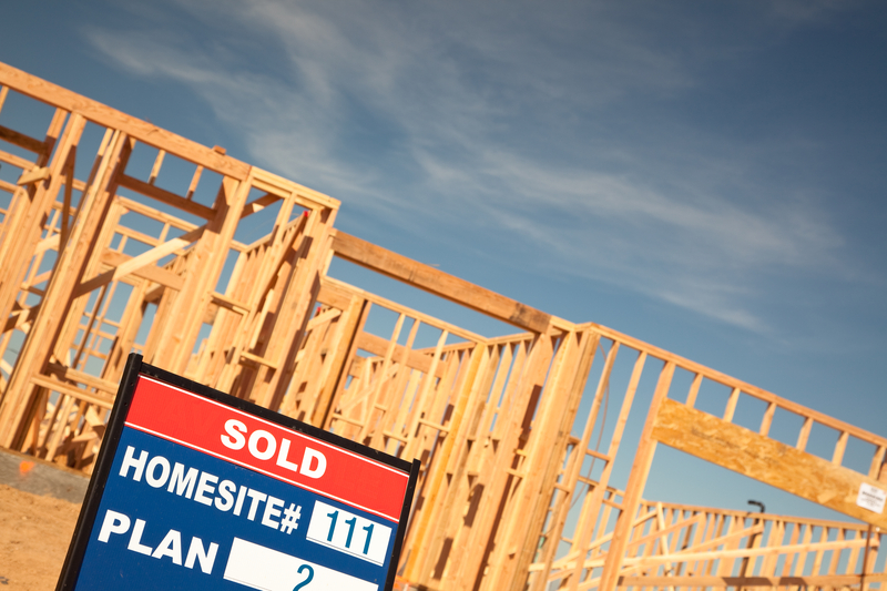 alt="New construction financing depicted by a Sold sign in front of a new home construction site"