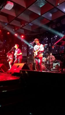 alt text = "rock band performing"