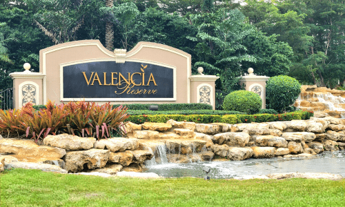 alt="Valencia Reserve sign set along waterfalls and tropical landscaping"