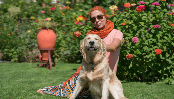 alt="Woman with her Golden Retriever in the backyard of her Florida 55+ community."