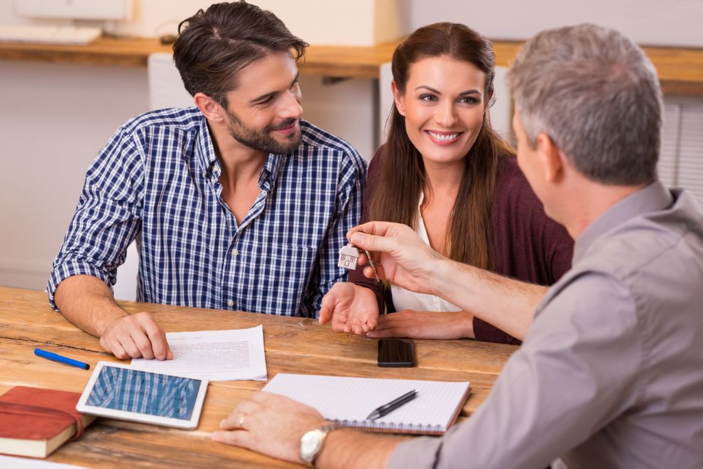 alt="Couple receiving keys links to tips on budgeting for a home purchase."
