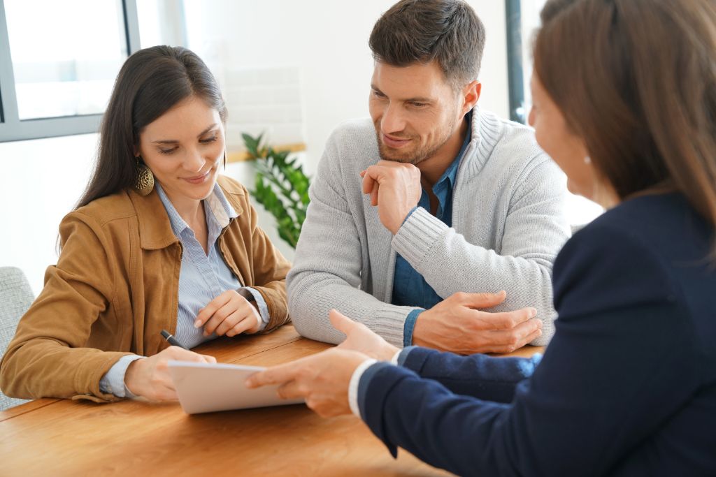 alt= "Couple signing closing docs links to a home purchase closing checklist."